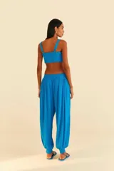 Pantalón babucha azul con brillos de látex, cinturilla ancha de látex, diseño amplio en crepé de viscosa con detalle de hilos de colores verticales a lo largo del pantalón y diseño recto con solapa elástica rematando el bajo.