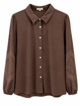 Camisa de manga larga color marrón chocolate, con cuello camisero, cierre frontal con botones claros y detalles de bordado geométrico en los codos.