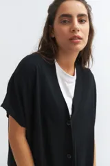 Cardigan negro de tejido de punto, corte amplio y mangas cortas.