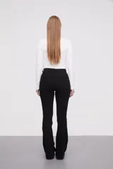 Pantalon jean de tiro alto con corte flare y terminación desflecada en el ruedo. Presenta un diseño clásico de cinco bolsillos con costuras en contraste.