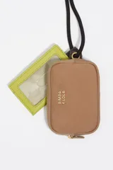 Monedero compacto de Bimba y Lola en color negro, con cierre de cremallera y cordón ajustable con nudos decorativos. Presenta el logo de la marca estampado en letras doradas en la parte frontal.