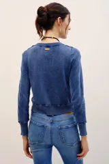Cardigan de punto con efecto denim, cuello redondo, cierre frontal con botones y mangas largas con puños acanalados.