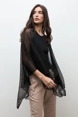 Ruana de tejido abierto con hilo de lurex dorado, diseño amplio y caída ligera.