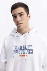 Canguro blanco de corte oversize con capucha y cordones ajustables. Presenta un estampado frontal con el texto 'BRIGHT FUTURE' en contorno azul y el logo de la marca en color naranja. Incluye bolsillos laterales.