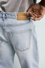 Jeans regular fit de denim de algodón en color gris con efecto lavado, tiro medio, diseño de cinco bolsillos y cierre frontal con botones.