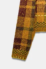 Jersey de punto con cuello perkins y manga larga, diseño a cuadros en tonos mostaza y marrón con detalles de costuras en color amarillo neón.