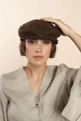 Boina con visera de lana fina uruguaya natural, sin teñir, con diseño de tejido texturizado en tonos beige y marrón.