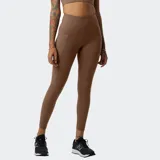 Calza deportiva New Balance Shape Shield 7/8 de tiro alto, color marrón, con paneles laterales y bolsillos integrados en la cadera.