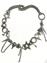 Collar de cadena gruesa de acero inoxidable con dijes colgantes variados que incluyen estrellas, cristales facetados, corazón, cruz y cadenas colgantes.