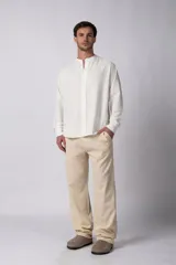 Camisa de manga larga color blanco roto, confeccionada en una mezcla de lino y viscosa, con cuello mao y corte relajado.