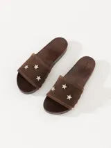 Zueco marrón de cuero vacuno descarne con base de madera y detalles de tachas. La capellada lleva apliques de estrellas con strass.