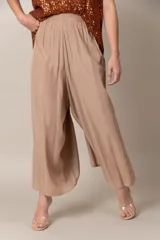 Pantalón ancho de seda color beige, con cintura elastizada y corte capri.