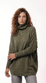 Sweater oversize de punto con cuello polera amplio, mangas largas con puños acanalados y costura central vertical. Presenta una silueta fluida y holgada.