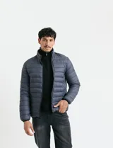 Campera acolchada tipo puffer en color gris, con cierre frontal, cuello alto y puños elásticos.