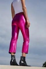 Pantalón de tiro alto confeccionado en bengalina engomada con acabado metálico brillante. Presenta un corte capri semi oxford con costura horizontal a la altura de la rodilla, cierre frontal con botón metálico y bolsillos funcionales.