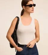 Musculosa de punto ligero color blanco, de corte ajustado, con cuello redondo y tirantes anchos.