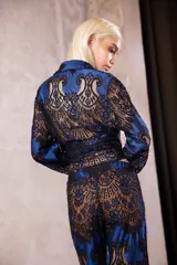 Pantalón de encaje con diseño de flores en color negro sobre base azul, de tiro medio con cintura elástica y corte oxford acampanado.