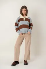 Buzo de tejido de punto con diseño de rayas horizontales anchas en color gris y marrón. Presenta cuello polo en tono crema con cierre frontal de dos botones y mangas largas con puños acanalados.