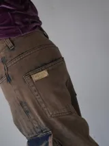Pantalón cargo oversize de jean, con múltiples bolsillos funcionales y detalles metálicos.
