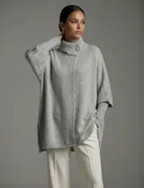 Capa tejida color fucsia, con cuello alto abotonado y mangas cortas estilo japonesa. Tejido de punto grueso.