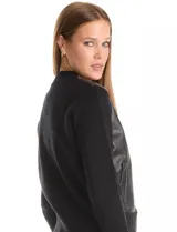 Campera tipo bomber combinada, con frente en cuero sintético y mangas y espalda tejidas. Presenta cuello a la base, cierre frontal y bolsillos laterales.