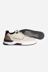 Zapatillas casuales marrones con cordones y suela blanca con detalles en negro.