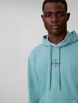 Buzo canguro Calvin Klein de color celeste, confeccionado en tejido French Terry. Presenta capucha con cordones ajustables, bolsillo frontal tipo canguro, puños y dobladillo acanalados, y el monograma de la marca bordado en el pecho.