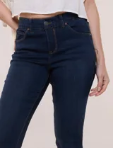 Pantalón jean de calce ajustado de corte skinny, color azul oscuro, con cintura de tiro medio con presillas y acceso frontal mediante cierre y botón metálico. Cuenta con diseño clásico de cinco bolsillos y pespuntes a contrapunto.
