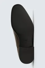 Zapato de vestir tipo Oxford en color negro, con diseño de puntera reforzada y cierre mediante cordones. Presenta una silueta clásica y elegante con tacón bajo.