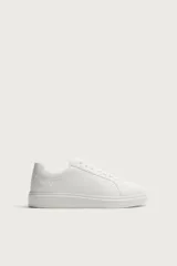 Zapatilla urbana monocolor blanca con cordones al tono, diseño de parte superior lisa, puntera redondeada y suela con volumen.