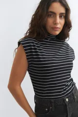 Musculosa negra con rayas horizontales blancas y cuello alto.