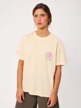 Remera de algodón color amarillo claro, con corte suelto y estampado gráfico en la espalda con diseño de muebles de playa y textos.