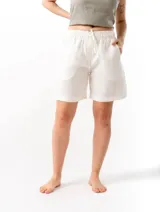 Short de lino con cintura elástica y cordón ajustable. Cuenta con dos bolsillos laterales y un bolsillo trasero, ofreciendo un ajuste cómodo y versátil.