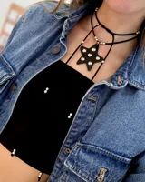 Gargantilla choker de acrílico negro con dije de estrella con incrustaciones brillantes. El collar es de doble tira de cuero sintético negro y tiene un largo ajustable.