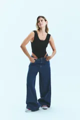 Jean de corte oversize confeccionado en denim de algodón con lavado azul clásico. Presenta tiro medio-bajo, cierre frontal con botón y bolsillos laterales.