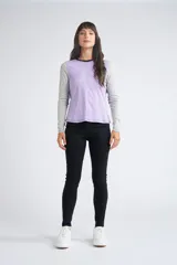 Remera de manga larga con diseño color block, combinando panel frontal en color lila, mangas en gris melange y espalda en negro. Presenta cuello redondo y costuras a la vista.