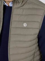 Chaleco acolchado verde militar, repelente al agua, con cierre frontal de cremallera y cuello alto. Cuenta con bolsillos laterales y detalle de logo en el pecho.