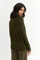 Sweater negro de tejido de punto fino, con cuello alto y mangas largas.