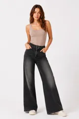 Pantalón jean ancho de tiro medio, en color gris con efecto acid wash. Presenta bolsillos delanteros, cierre frontal con cremallera expuesta y cinturón incorporado con hebilla metálica.