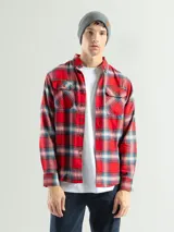 Camisa de franela a cuadros color celeste, gris y negro, de manga larga con dos bolsillos frontales con solapa abotonada.