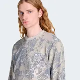 Remera de manga larga Adidas Originals con textura tipo waffle y estampado de camuflaje en tonos grisáceos y beige. Presenta un corte holgado y el logo de la marca bordado en el pecho.