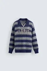 Polo de punto cepillado con diseño de rayas horizontales en azul marino y gris. Presenta cuello solapa con abertura frontal, manga larga y texto bordado en el pecho. Acabados en rib en puños y ruedo.