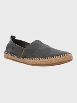 Alpargatas Hush Puppies modelo Hubert, color negro, con suela de yute trenzado y costuras decorativas. Diseño slip-on con elástico en el empeine.