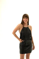 Top negro de cuero sintético con cuello halter y flecos en el frente.