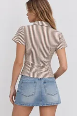 Blusa a rayas verticales en color marrón y blanco, con cuello camisero, manga corta y cierre frontal con botones.