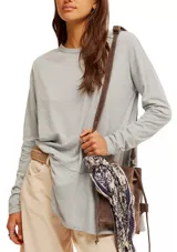 Camiseta gris de manga larga con cuello redondo y corte holgado.