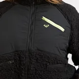Campera de polar tipo sherpa color negro, con paneles frontales de tela técnica, cierre frontal completo y bolsillos con cierre. Presenta un bolsillo adicional en el pecho con cierre en contraste color verde lima.