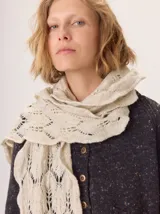 Bufanda de lana tejida con diseño de trama abierta y textura irregular, en tonos amarillo mostaza y blanco.