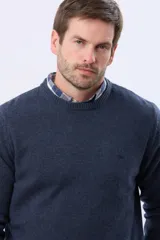 Buzo tejido de lana con escote redondo a la base y mangas largas. Presenta puños y ruedo acanalados, con un pequeño logo bordado en el pecho.