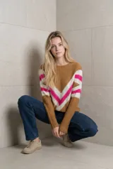 Sweater de tejido tricot con diseño chevron en forma de V en el frente, combinando colores marrón, blanco y fucsia. Presenta cuello redondo, mangas largas y terminaciones en rib.